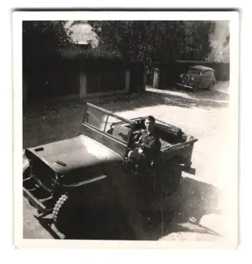 Fotografie Ansicht München-Obermenzing, amerikanischer Besatzungssoldat in seinem Willys Jeep, 1947, Pflgerstrasse