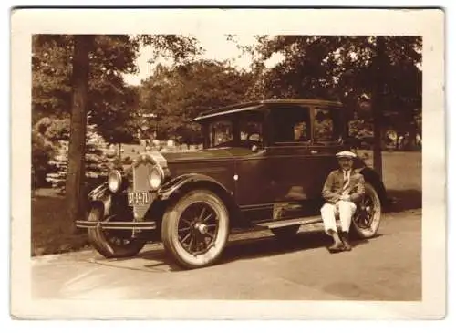 Fotografie Mann sitzt auf der Trittleiste seines Buick Auto, Kennzeichen: 3T-14-71