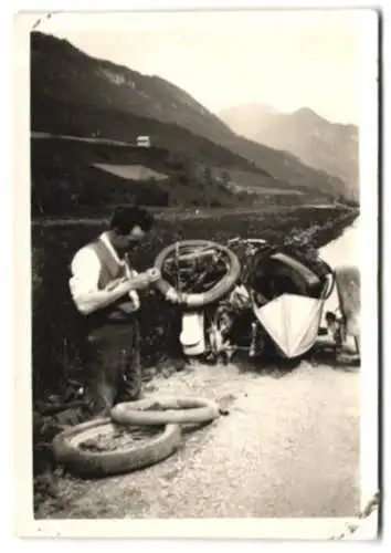 Fotografie Mann flickt den Schlauch seines Motorrad bei einer Panne, Motorrad Gespann