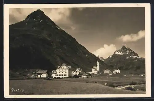 AK Galtür, Ortsansicht mit Bergspitzen und Fluss