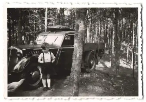 Fotografie kleiner Junge neben einem Audi LKW im Wald