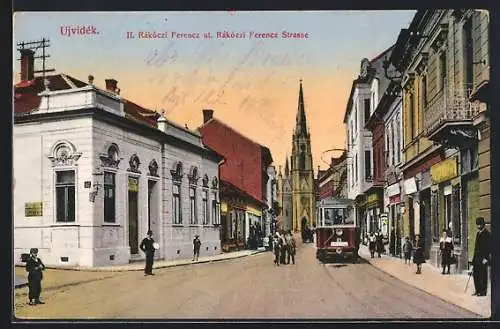 AK Ujvidék, Rakoczi Ferencz Strasse mit Abzweig, Kirche und Strassenbahn