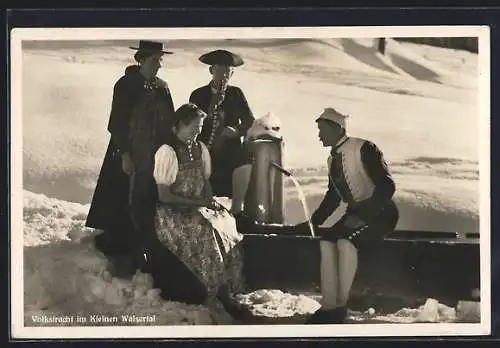 AK Vorarlberg, Gruppe an Brunnen im Schnee in Volkstracht im Kleinen Walsertal