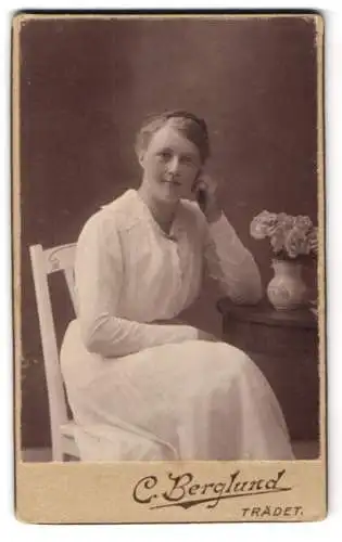 Fotografie C. Berglund, Trädet, Frau in weissem Kleid an Tisch mit Blumen