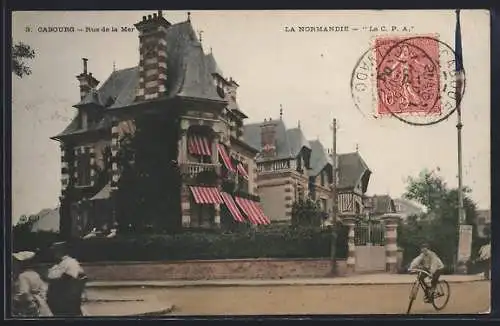 AK Cabourg, Rue de la Mer avec cycliste et maisons élégantes