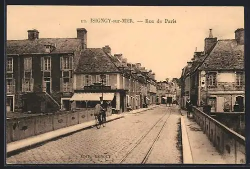 AK Isigny-sur-Mer, Rue de Paris avec un cycliste et des bâtiments historiques
