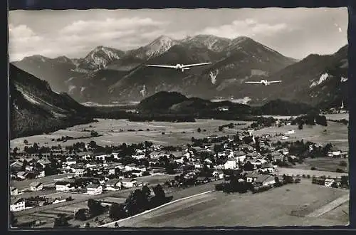 AK Unterwössen /Bay., Gesamtansicht mit fliegenden Flugzeugen aus der Vogelschau