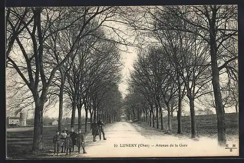 AK Lunery, Avenue de la Gare avec des passants et arbres dénudés en hiver