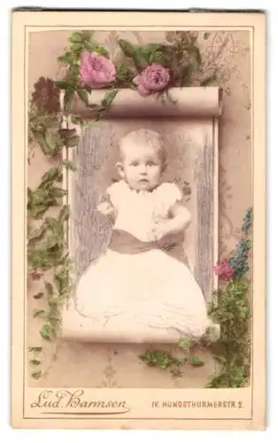 Fotografie Lud. Harmsen, Wien, Kleinkind im Taufkleid, Passepartout mit floraler Verzierung