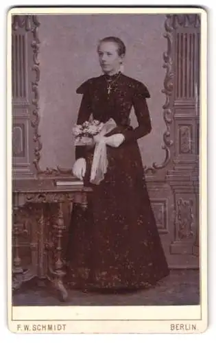 Fotografie F. W. Schmidt, Berlin, Wasserthorstrasse 56, Dame im eleganten Kleid mit Blumenstrauss