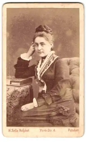 Fotografie H. Selle, Potsdam, York Str. 4, Frau in elegantem Kleid sitzt nachdenklich im Sessel