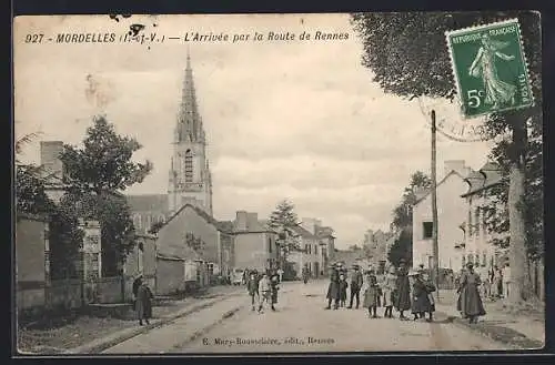 AK Mordelles, L`Arrivée par la Route de Rennes avec vue de l`église et passants