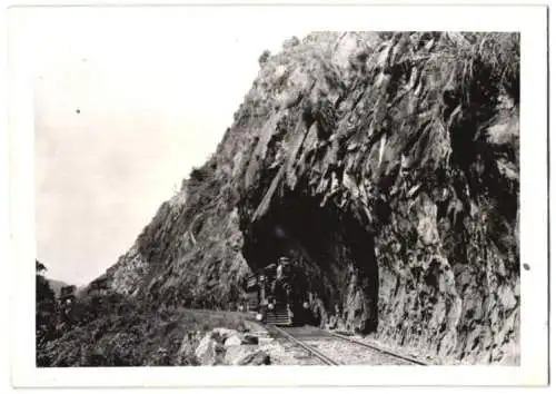 Fotografie Schostal, Ansicht Ceylon - Sri Lanka, Eisenbahn, Personenzug mit Dampflok unter Felsvorsprung 1941