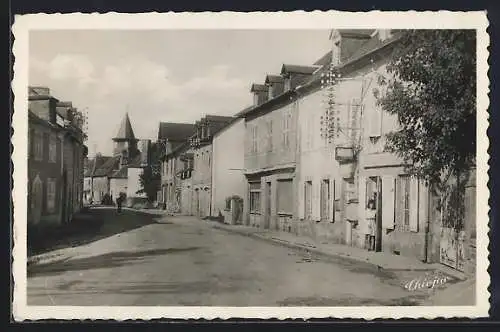 AK Lonzac, Rue principale avec maisons traditionnelles et clocher au fond