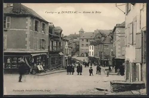 AK Donzenac, Avenue de Brive avec passants et maisons anciennes