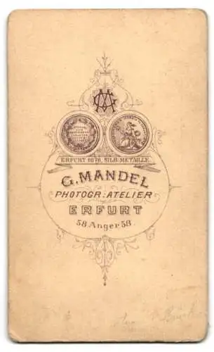 Fotografie G. Mandel, Erfurt, junge Frau im Wintermantel mit Muff und Hut