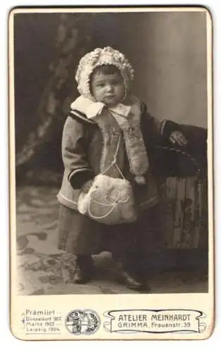 Fotografie Atelier Mainhardt, Grimma, niedliches Kleinkind im Winterkleid mit Muff und Haube