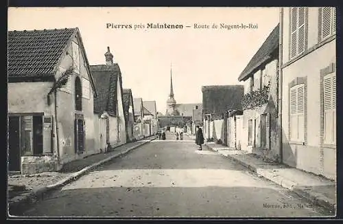 AK Pierres, Route de Nogent-le-Roi près de Maintenon avec des maisons et une église au fond