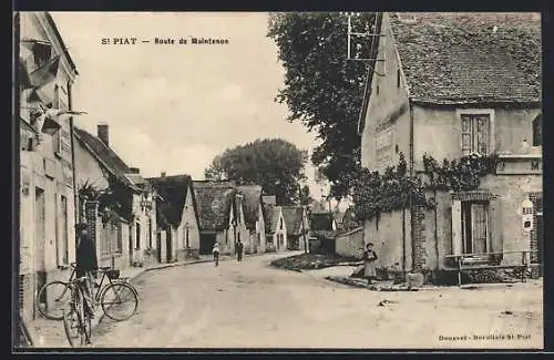 AK Saint-Piat, Route de Maintenon avec cycliste et maisons anciennes