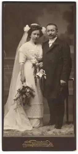 Fotografie M. Scheinfuss, Reichenbach i. V., junges Brautpaar im Hochzeitskleid und Anzug mit Chapeau Claque