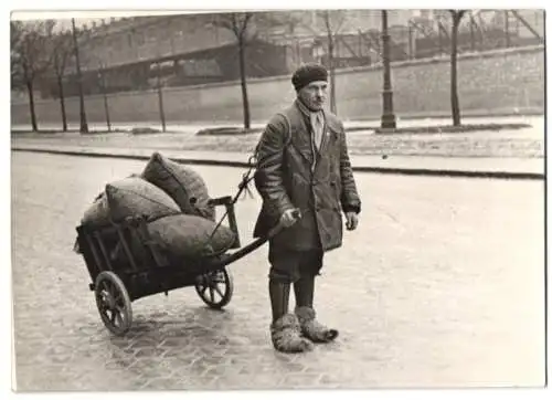 Fotografie Swoboda, Ansicht Wien, Mann mit Wagen hat Schuhe mit Lappen umwickelt wg. dem Glatteis 1938