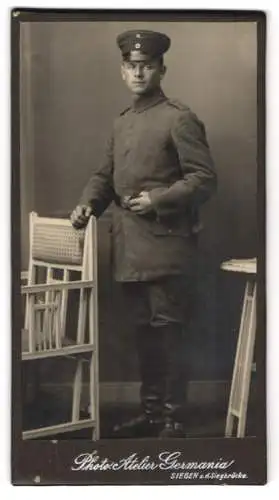 Fotografie Photo Atelier Germania, Siegen, a.d. Siegbrücke, Soldat in Uniform Feldgrau mit Schirmmütze