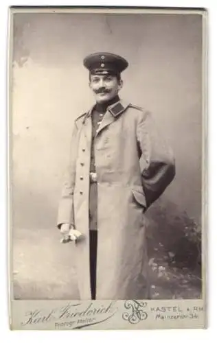 Fotografie Karl Friedrich, Kastel A. RH., Mainzerstr. 34, Soldat in Uniform mit Mantel und Schirmmütze