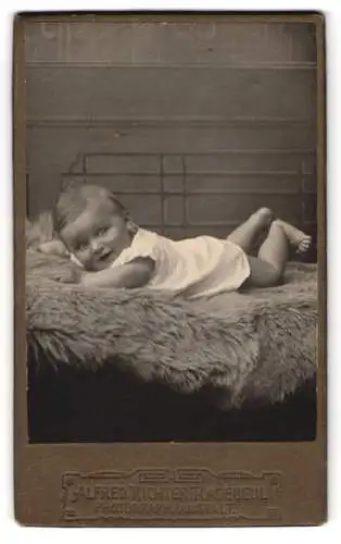 Fotografie Alfred Richter, Radebeul, Baby auf Pelz liegend