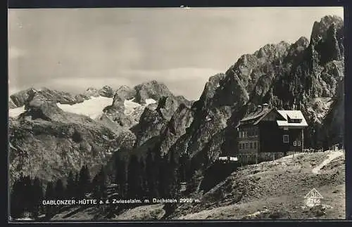 AK Gablonzer-Hütte auf der Zwieselalm mit Dachstein, Aussenansicht der Berghütte mit Aussicht den Hang hinab