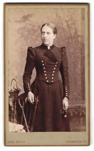 Fotografie Carl König, Naumburg a/S, Lindenstrasse 4, Frau in elegantem Kleid mit Blumenarrangement