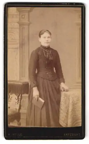 Fotografie A. Wille, Harzburg, Frau mit Buch in tailliertem Kleid