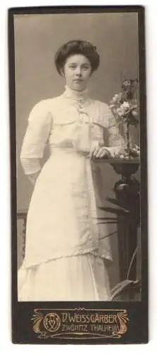 Fotografie D. Weissgärber, Zwönitz, Elegante Dame im weissen Kleid neben Blumendekoration