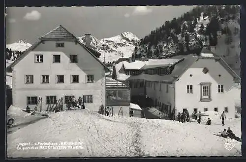 AK Obertauern, Jugend- und Ferienhaus Bergheim Radstädter Tauern mit Skifahrern im Schnee