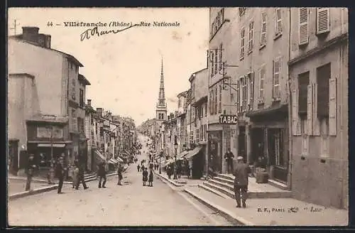 AK Villefranche, Rue Nationale avec église en arrière-plan et passants animant la rue