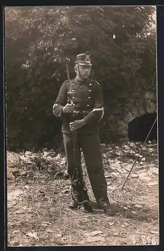 Foto-AK Bewaffneter schweizer Soldat in Uniform vor einer Brücke