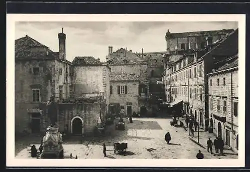 AK Dubrovnik, Strassenpartie mit Denkmal und Passanten