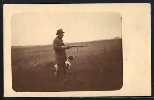 AK Jäger mit Hund steht an einem Feld