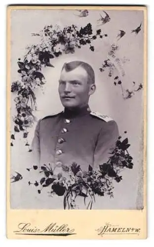 Fotografie Louis Müller, Hameln, Münsterkirchhof 5, Portrait eines Soldaten in Uniform mit floralem Rahmen