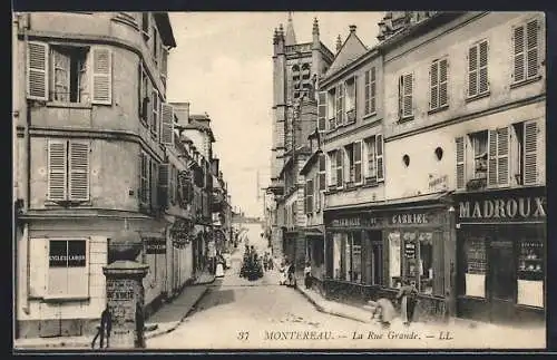 AK Montereau, La Rue Grande animée avec boutiques et église en arrière-plan