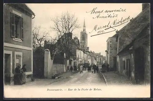 AK Donnemarie, Rue de la Porte de Melun avec passants et église en arrière-plan