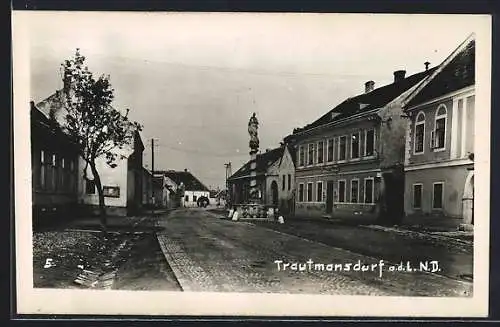 AK Trautmannsdorf a. d. L., Strassenpartie mit Denkmal