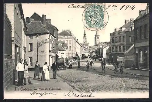 AK Cateau, Rue de Cambrai avec scène de rue animée et église en arrière-plan