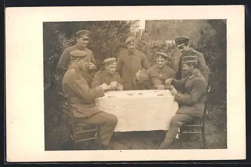 Foto-AK Soldatengruppe beim Kartenspiel in einem Garten