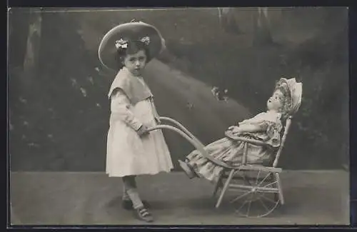 Foto-AK Mädchen mit Puppe im Puppenwagen vor Gartenkulisse