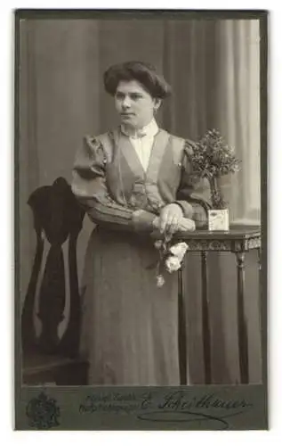 Fotografie E. Scheithauer, Zwickau, Innere Plauensche Str 20, Frau mit elegantem Kleid neben einem Tisch