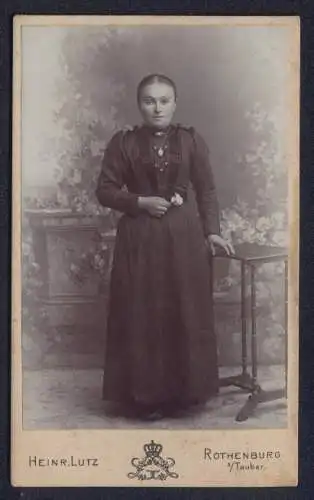 Fotografie Heinr. Lutz, Rothenburg, Frau in dunklem Kleid mit Tisch