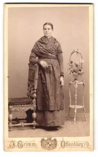 Fotografie J. Grimm, Offenburg, Frau mit Schal neben Stuhl und Blumenständer