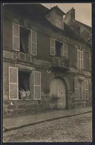 AK Saint-Arnoult-en-Yvelines, Maison avec habitants à la fenêtre dans la rue pavée