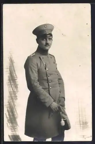 Foto-AK Soldat im Uniformmantel mit Schirmmütze, Uniformfoto