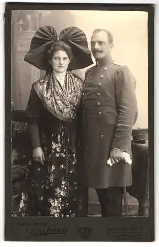 Fotografie louis Frohwein, Strassburg i. Els., Offizier in Uniform nebst seiner Frau in Elsässer Tracht